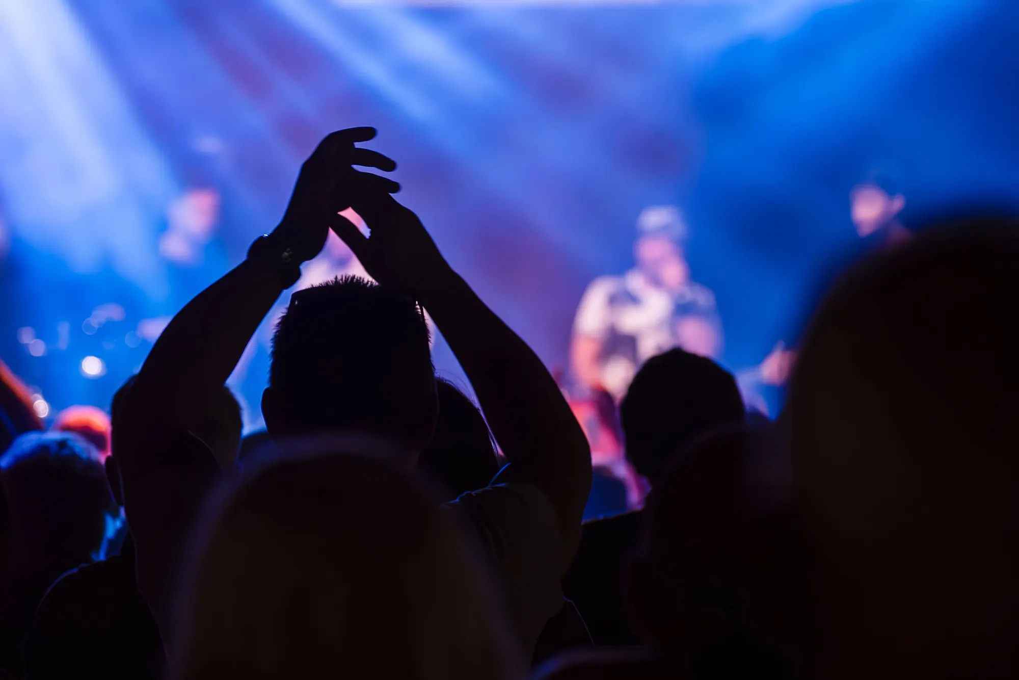 A band performing on stage to a full live music venue